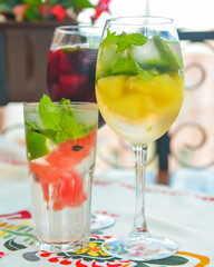 Glasses of red wine and white wine with watermelon pieces on the table. Delicious cold fruit drink served in glasses.