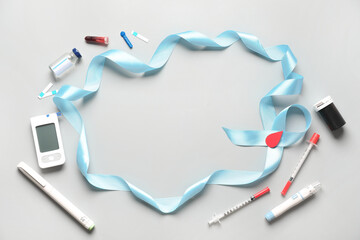 Frame made of awareness ribbon, glucometer and syringes on grey background. Diabetes concept