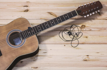 Guitar twelve-stringed on a board background and headphones. Filters for Instagram.