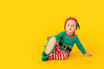 Cute little baby in elf's costume on color background