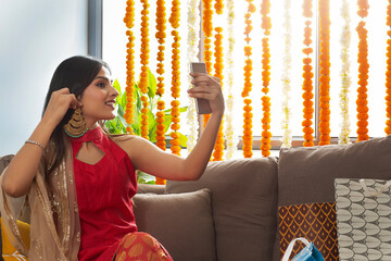 young beautiful girl trying on earrings and looking in to the phone	