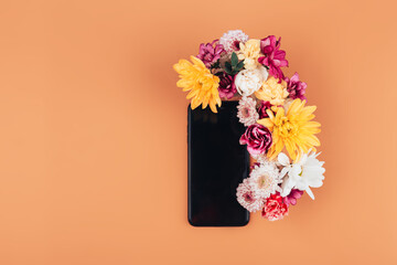 A mix of various colors next to a black phone, a gift for any occasion, a gift to a loved one on an orange background