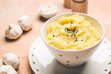 Bowl with tasty mashed potato and garlic on table