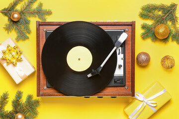 Record player and Christmas decor on color background