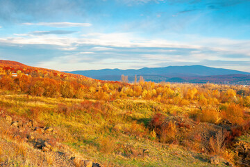 rural valley at sunset. beautiful autumn landscape in mountains. village in the distant valley. clouds on the blue evening sky