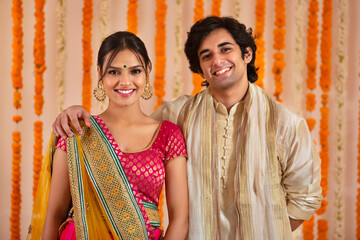 young couple happily posing together in traditional wear for Diwali	