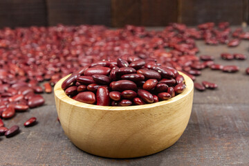 Red kidney beans on wooden bowl on wooden background.