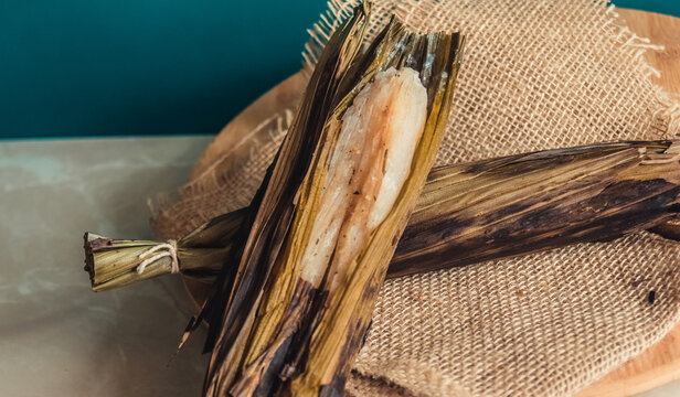 Brazilian traditional dessert. Bolo de tapioca (mane doido, pe de zumbi or pe de moleque nordestino similar to carim&atilde;, cassava cake). Brazilian cake made from tapioca flour, wrapped in banana leaves.
