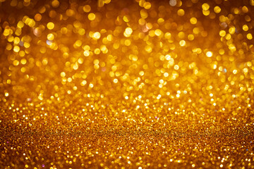 Abstract gold Christmas glowing background with shiny defocused lights, bokeh
