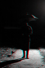 dark silhouette of a man in a raincoat and hat under an umbrella on the street in the rain