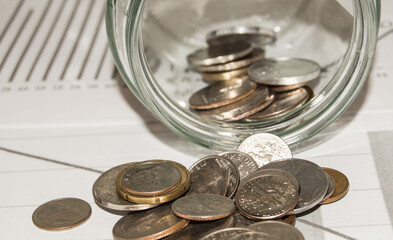 Close-up of Euro coins in a glass jar, scattered on the table, the concept of saving and investing