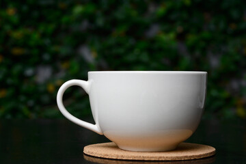 BLACK COFFEE IN WHITE CUP, ISOLATED ON NATURAL BACKGROUND