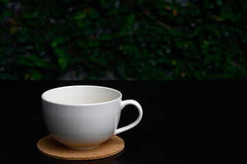 BLACK COFFEE IN WHITE CUP, ISOLATED ON NATURAL BACKGROUND