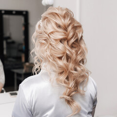 festive hairstyle of curls on the hair of a blonde. photo from the beauty Studio
