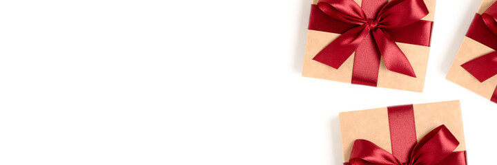 Banner with gift boxes tied with red ribbons on a white background with copy space. Wrapped present.