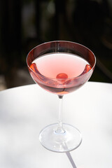 Red cocktail in martini glass with cherry. Exotic alcoholic cocktail