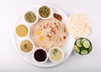 Vegetable Gujarati kathiyawadi thali on table, Full Gujarati dish mouth watering, traditional dishes,  indian Meal is a combination of different kinds of dals, sweet dishes, rice and roti.