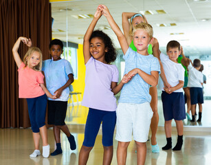 Positive little boys and girls dancing pair dance in the ballet studio. High quality photo