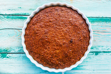 Homemade pumpkin pie on a wooden background.