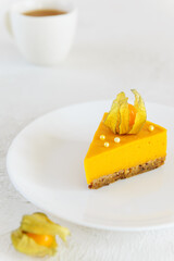 A slice of homemade pumpkin and orange cake on a white table. Sugar, lactose, gluten free.