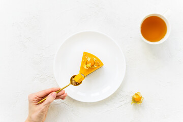 Slice of pumpkin cake with a spoon in hand. Sugar, lactose, gluten free. Horizontal orientation, top view.
