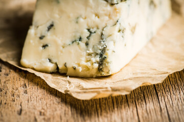 Tasty blue cheese on the rustic background. Selective focus. Shallow depth of field.
