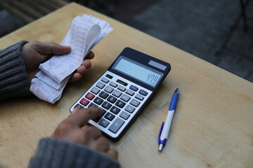 Man calculates bills using calculator.