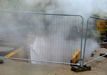 repairing pipes with hot water or steam in a deep armored pit that resembles a mine from which mist...