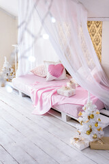 Christmas bedroom interior: four-poster bed and white Christmas trees. Christmas decorations in pink and gold colors