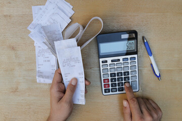 Man calculates bills using calculator.