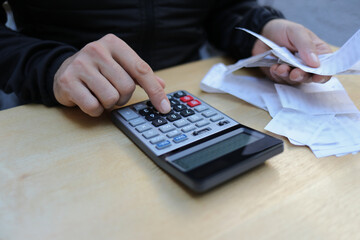 Man calculates bills using calculator.