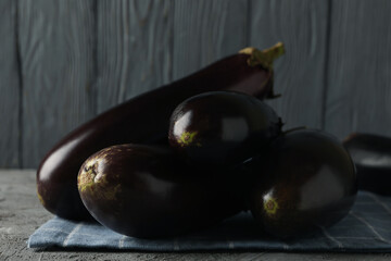 Napkin with fresh eggplants on gray background