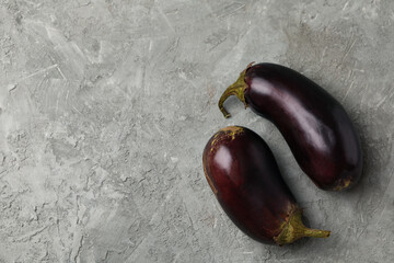 Fresh raw eggplants on gray background, space for text