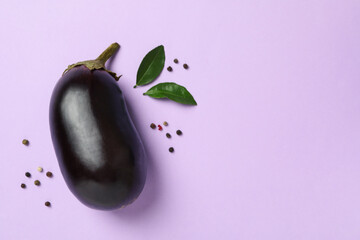 Fresh raw eggplant on violet background, space for text