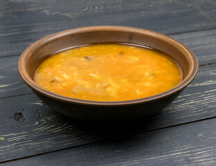 Pickle soup in a plate on a wooden table