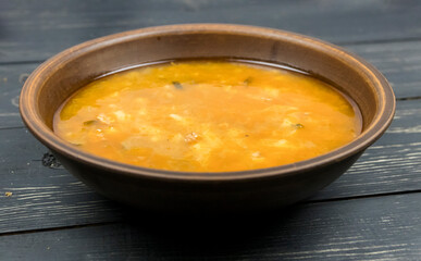 Pickle soup in a plate on a wooden table