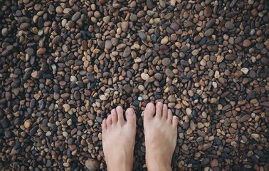 Barefoot on small pebbles stone on ground, feel relax and therapy, nature therapy