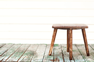 wooden stool on an old vintage wooden table on a blurry background. Mock up for display of product