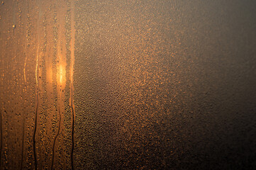 Drops of water on the fogged glass in the morning light. Selective focus. Background.
