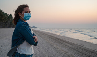Young woman with protect face mask travel at the beach in Thailand