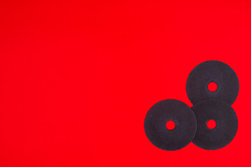 A cut-off wheel for a grinder tool on a red background with a place for copyspace text. Tools for construction and repair, workshop.