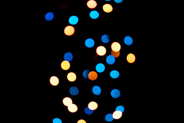 A brilliant glowing background side on black. The glitter light bokeh for the New Year and other holidays. Place for text copyspace.