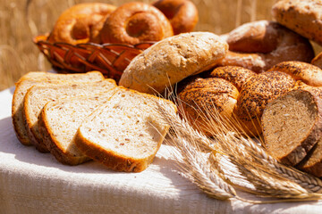 lot of different flavored bread, wheat, rye, on the table in the field outside