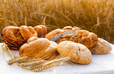 lot of different flavored bread, wheat, rye, on the table in the field outside