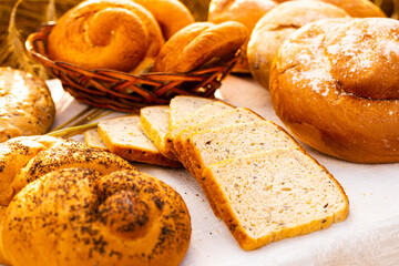lot of different flavored bread, wheat, rye, on the table in the field outside
