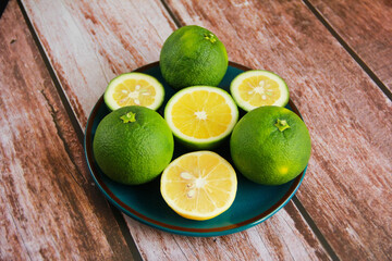 green lemon and round yellow lemon a slices