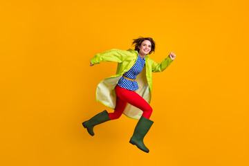 Full length photo portrait of happy girl running jumping up isolated on vivid yellow colored...