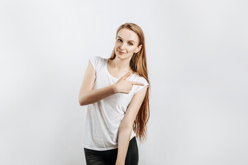 Young beautiful girl smiling and showing finger to the side on gray isolated background