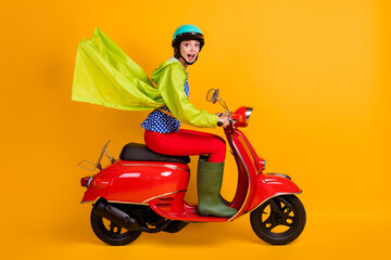 Full length photo portrait of excited girl riding bike isolated on bright yellow colored background