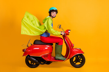 Full length photo portrait of smiling girl on motorbike isolated on vivid yellow colored background